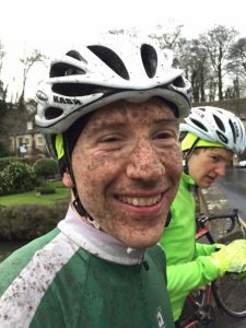 The face of a tired and muddy but happy cyclist